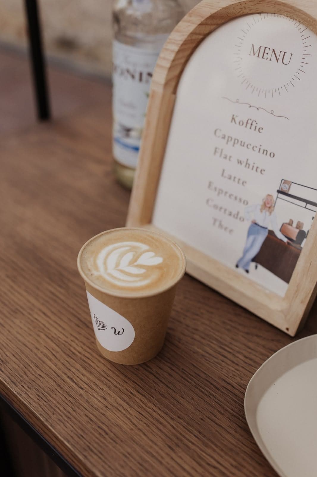 Latte met latte art naast het menubordje